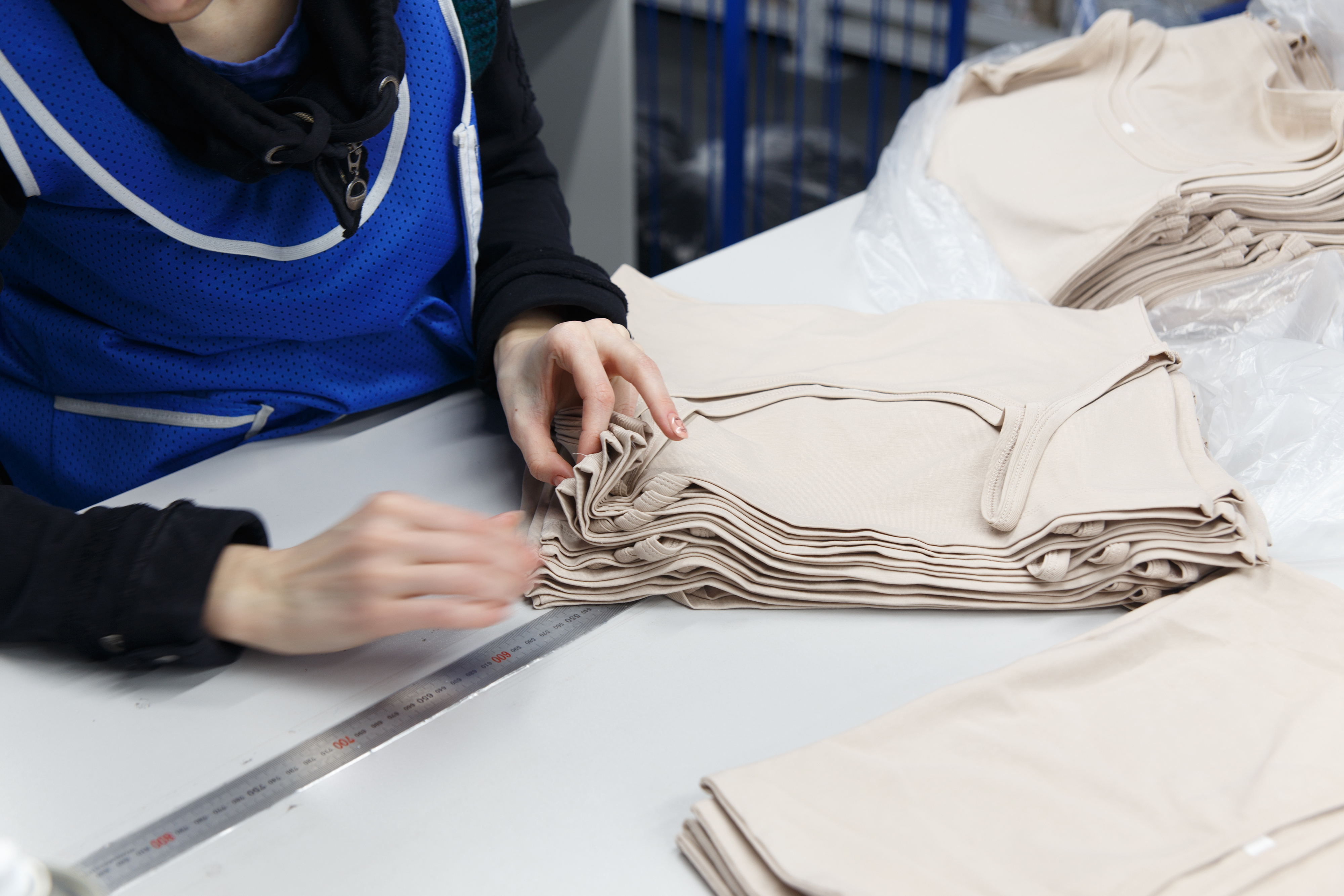 A hand inspecting high-quality wholesale activewear, symbolizing the need to check technical specifications like GSM (grams per square meter) before sourcing