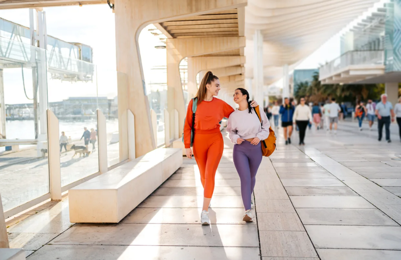 لقطة مقربة ليد عارضة أزياء تضع هاتفًا ذكيًا في جيب جانبي آمن وخالٍ من الارتداد في سروال ضيق عالي الأداء، مما يوضح وظائف الملابس الرياضية الأساسية والتخزين